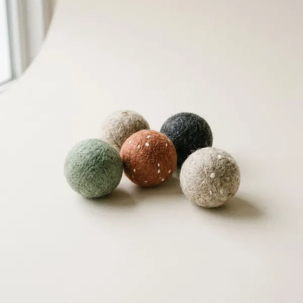 Four felted wool cat balls in sage, oatmeal, terracotta and charcoal
